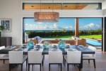 Gather around in an elegant dining space with expansive windows showcasing ocean views.