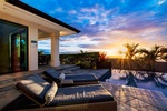 Poolside loungers beside the infinity pool with sweeping Kona coast views.