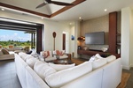 Enjoy sophisticated comfort in this open-concept living room with a coastal touch and pool views.