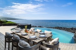 Outdoor dining along the lanai, with the pool at your side and the Pacific just beyond.
