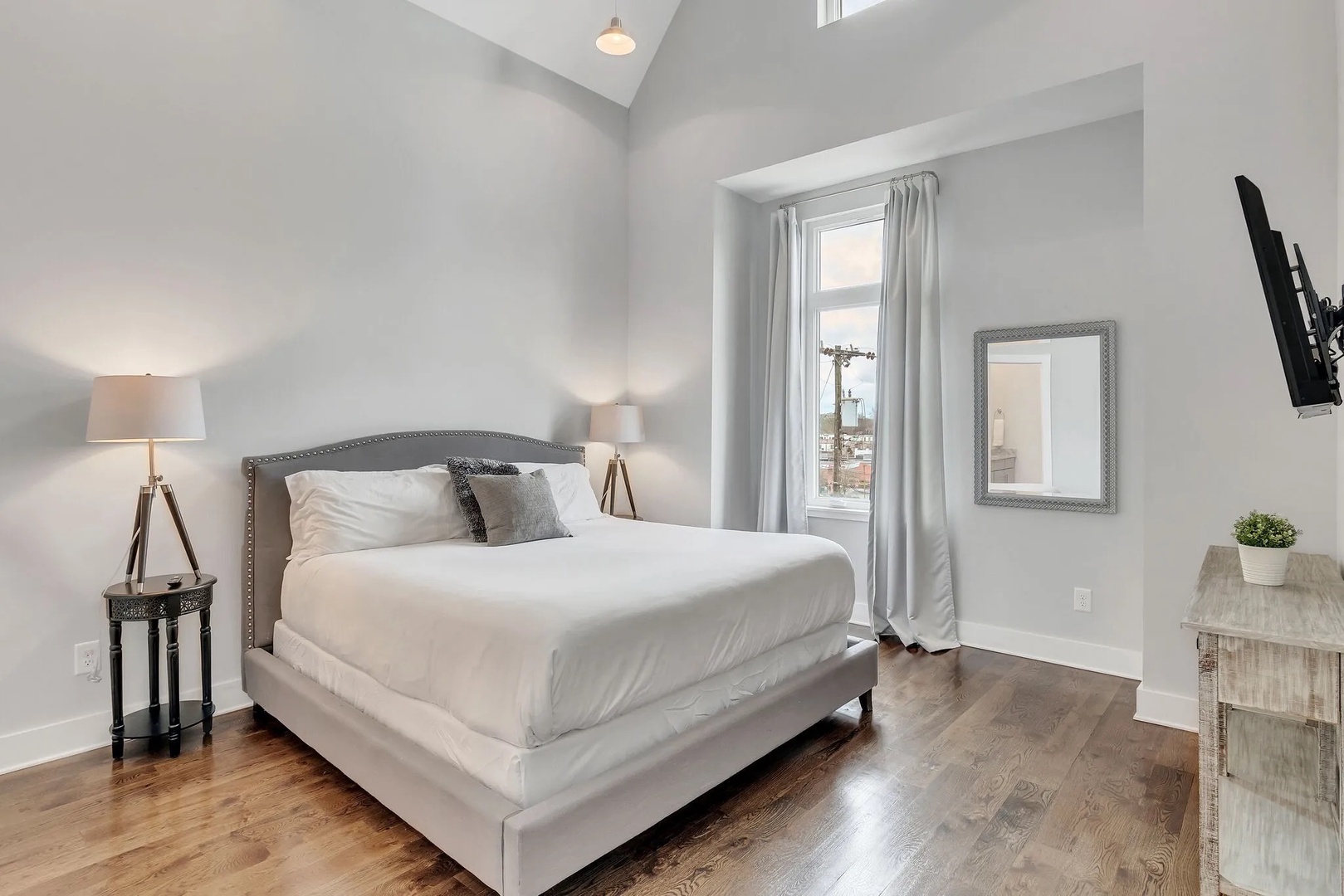 Primary bedroom with king bed TV and ensuite bathroom