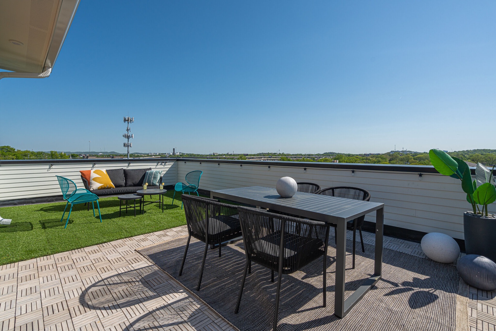 Private rooftop deck outdoor dining table (seats 4) and lounge area. Entire space is lined with bistro lights and includes a photo op mural!