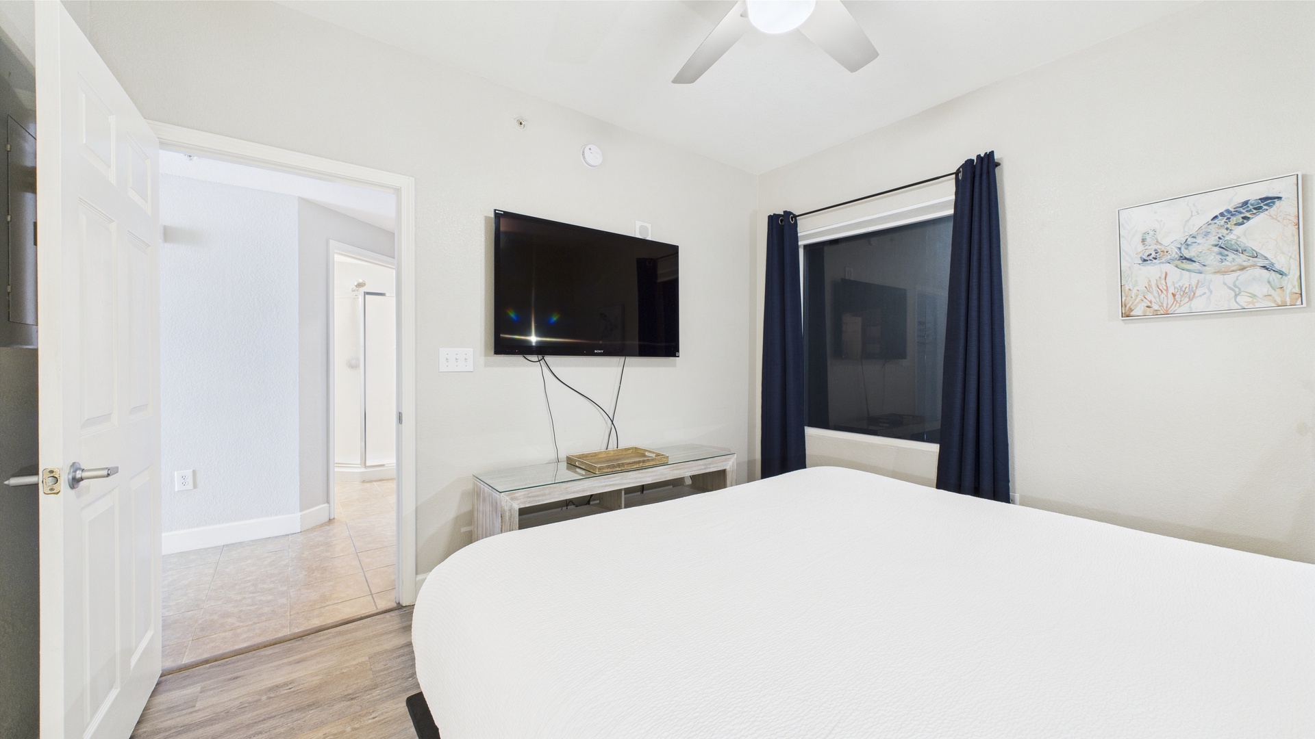Master bedroom with king bed TV and ensuite bathroom