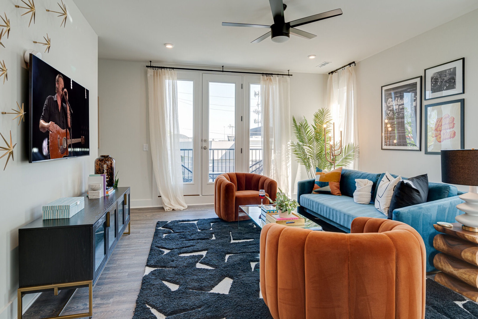Bright and open living space draped in designer furnishings. Complete with sofa, smart TV, and 2nd floor balcony.