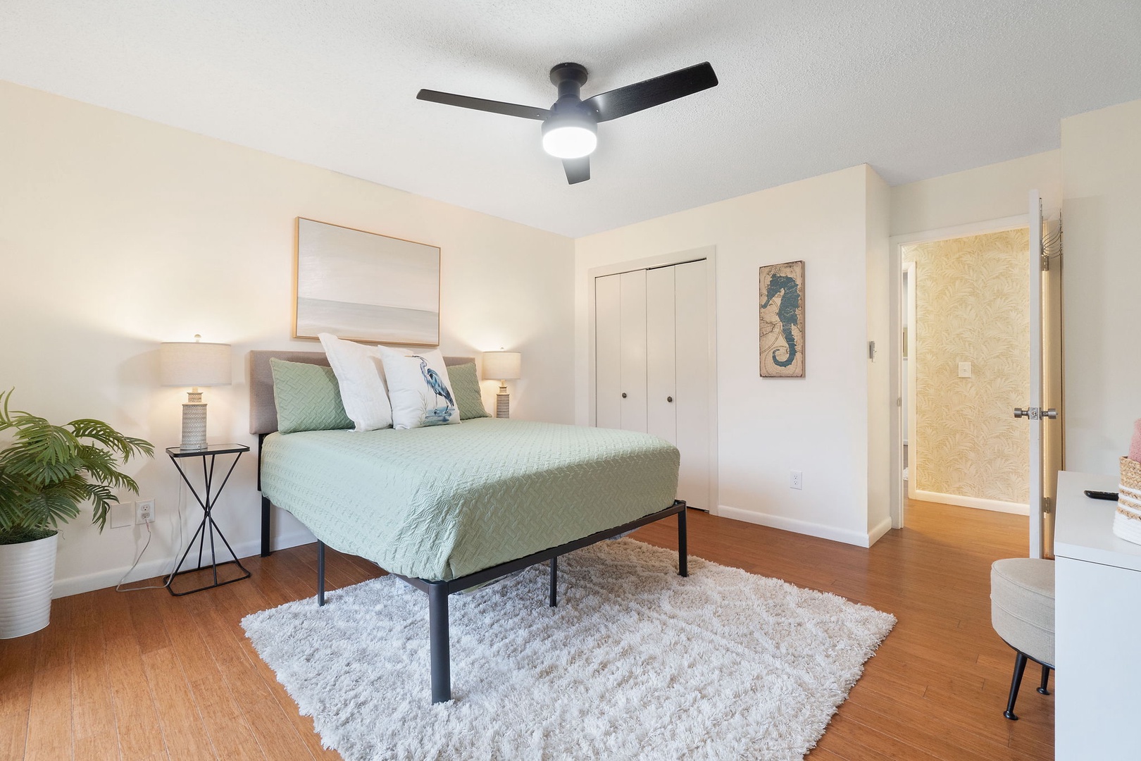 Guest bedroom with queen bed TV and balcony access