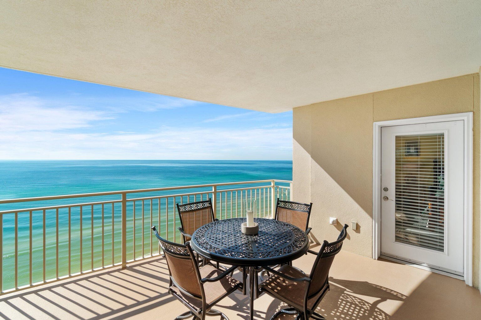 Balcony with dining table and coastal views