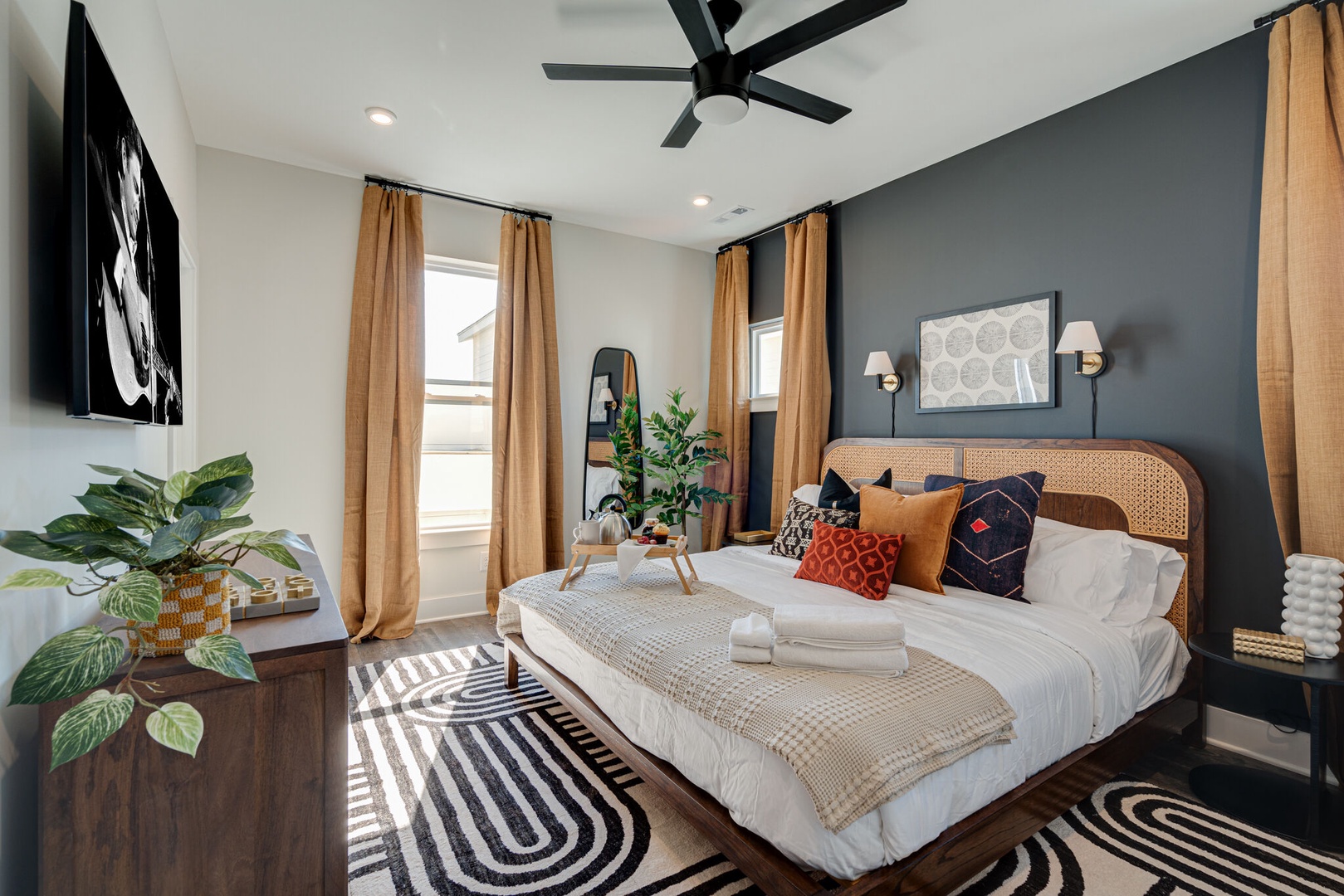 Primary bedroom with King bed, designer furnishings, smart TV, closet, and en-suite bathroom.