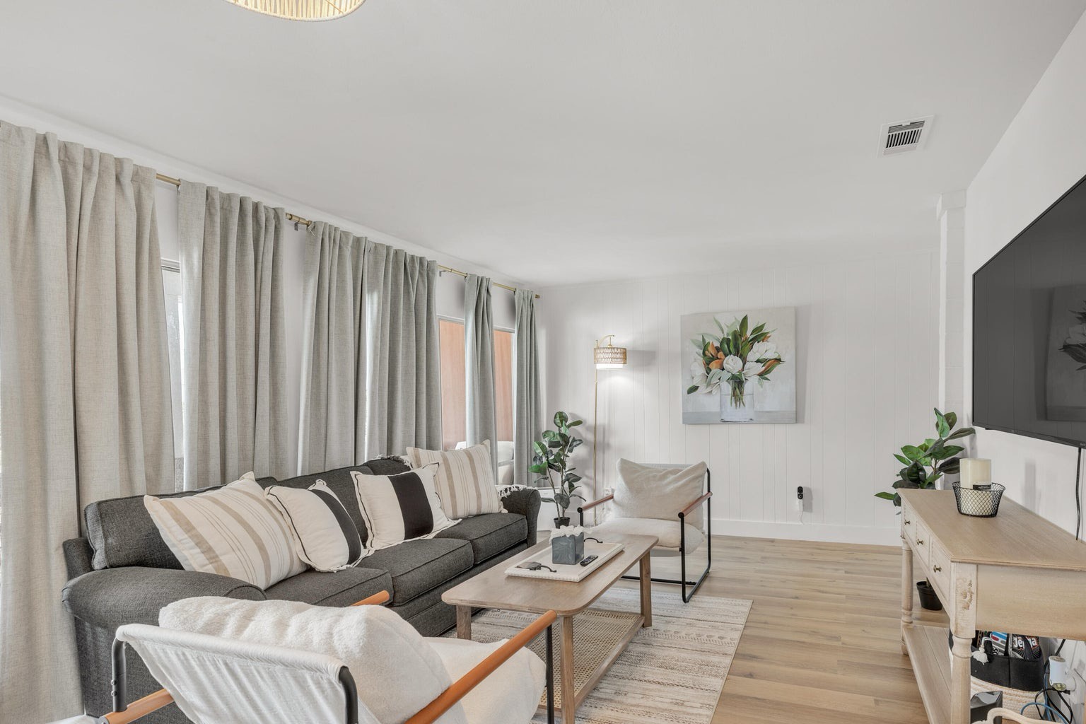 Open concept living area with stylish furnishings TV and pull out couch