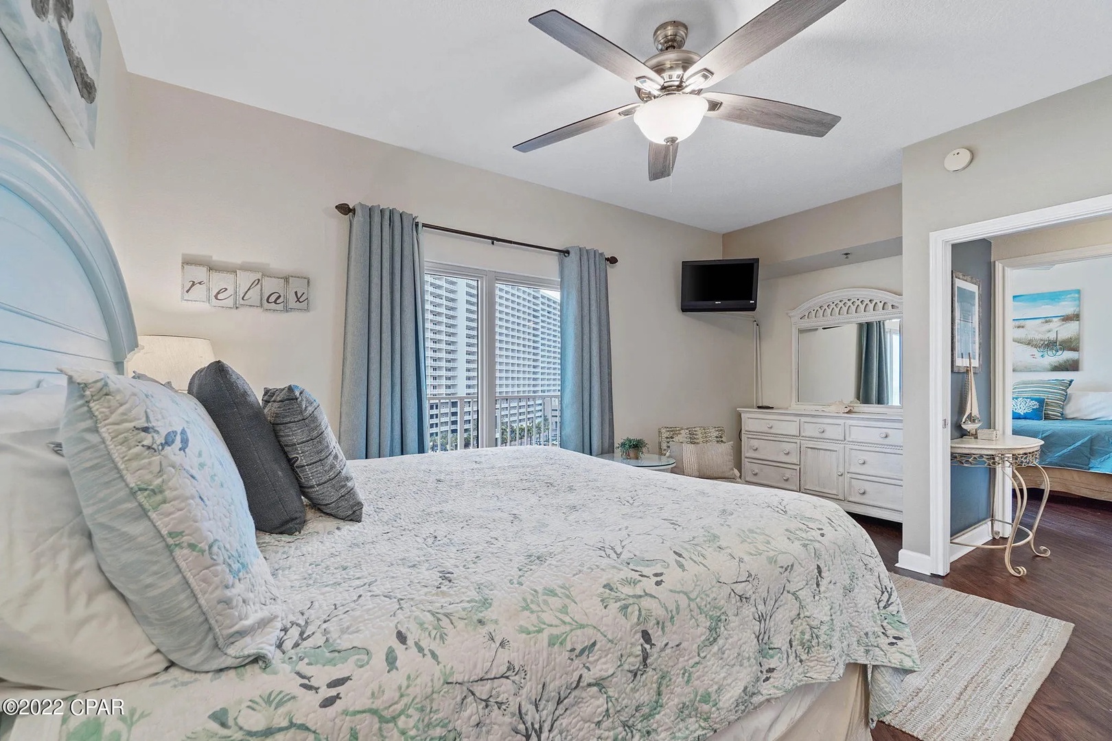 Primary bedroom with king bed, TV, and scenic views. Features an ensuite bathroom.