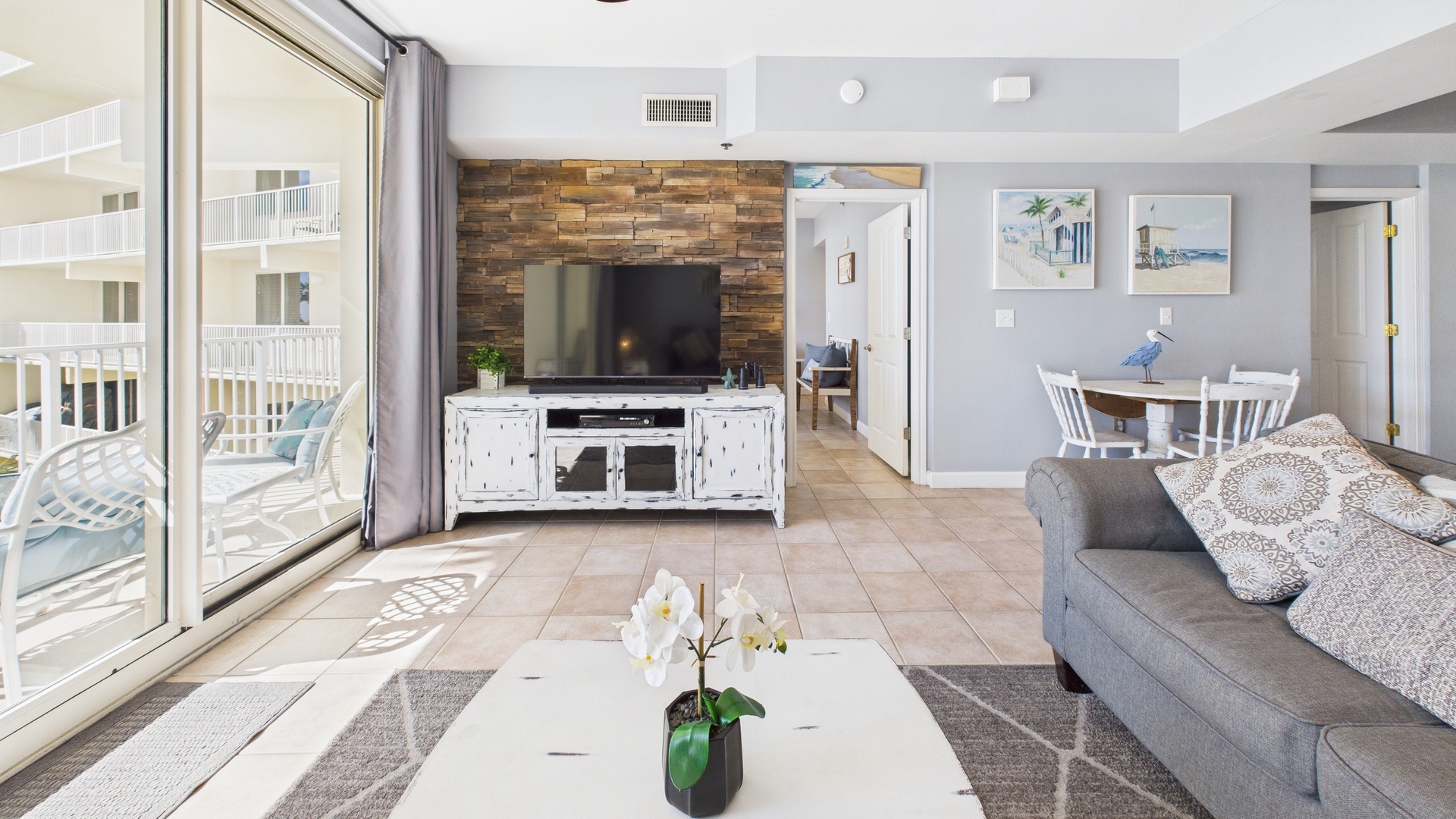 Open concept living area with sleeper sofa TV and balcony access