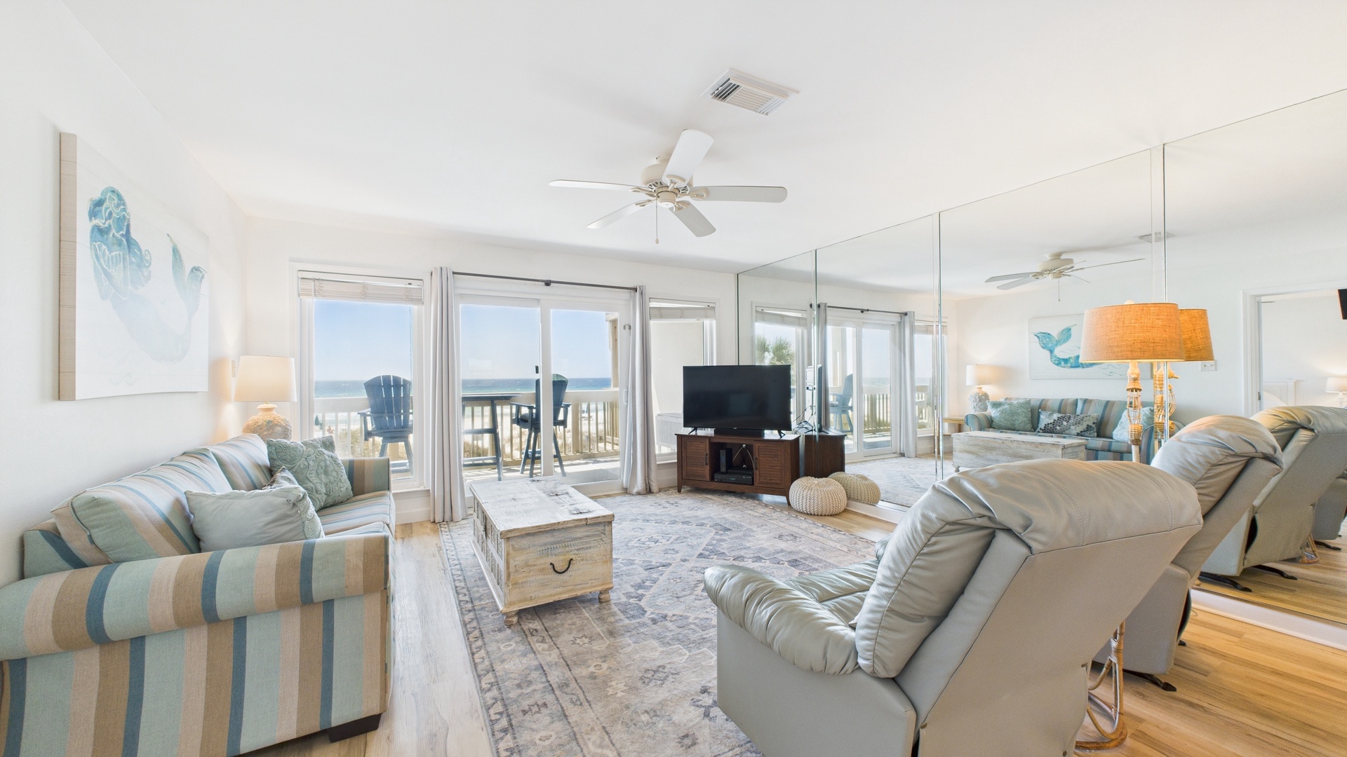 Open concept living area with stylish furnishings sleeper sofa TV and balcony access