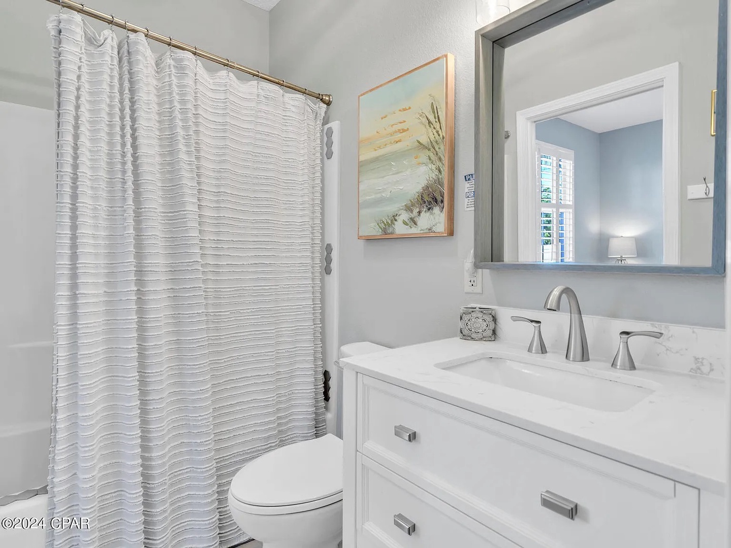 Full bathroom at end of hallway with shower/tub combo