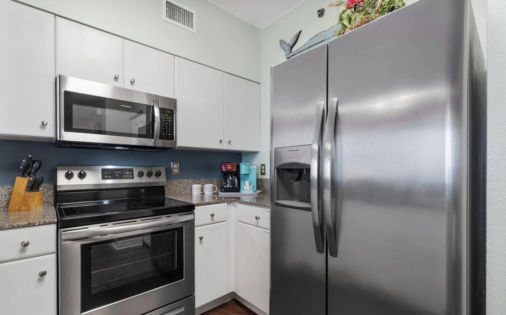 Full kitchen with stainless steel appliances and equipped with basic cooking essentials.