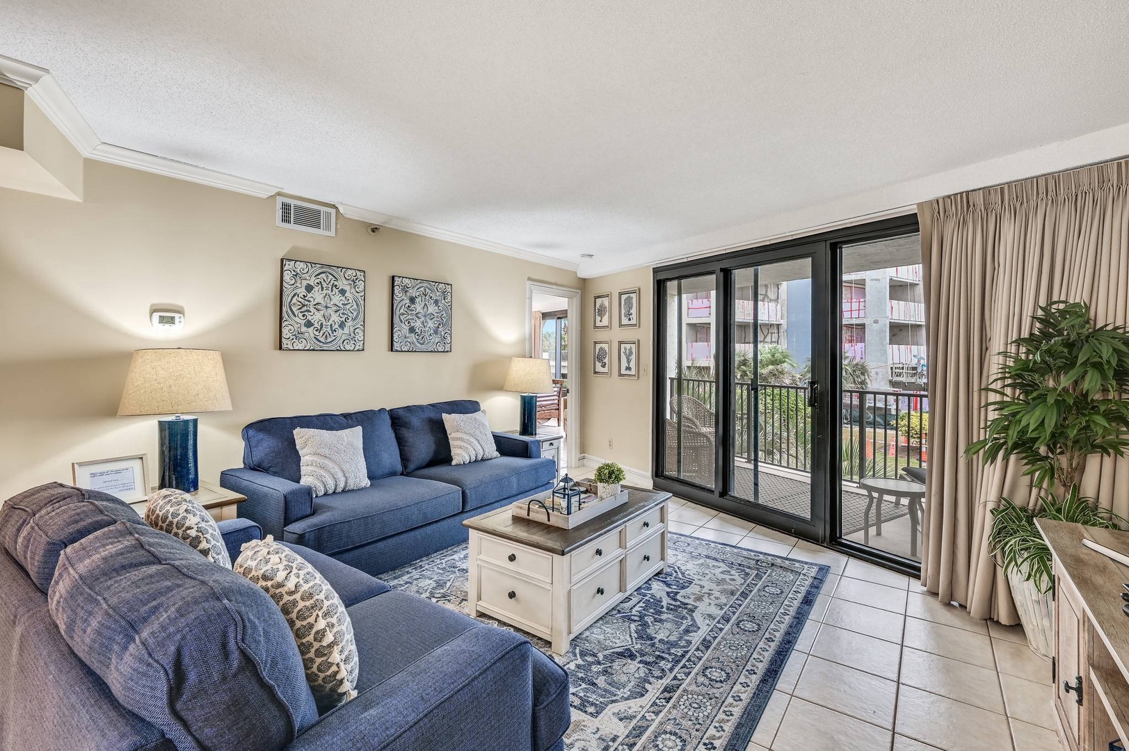 Open concept living area with TV balcony access and sleeper sofa