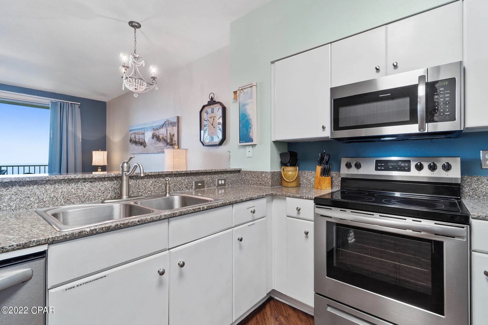 Full kitchen with stainless steel appliances and equipped with basic cooking essentials.