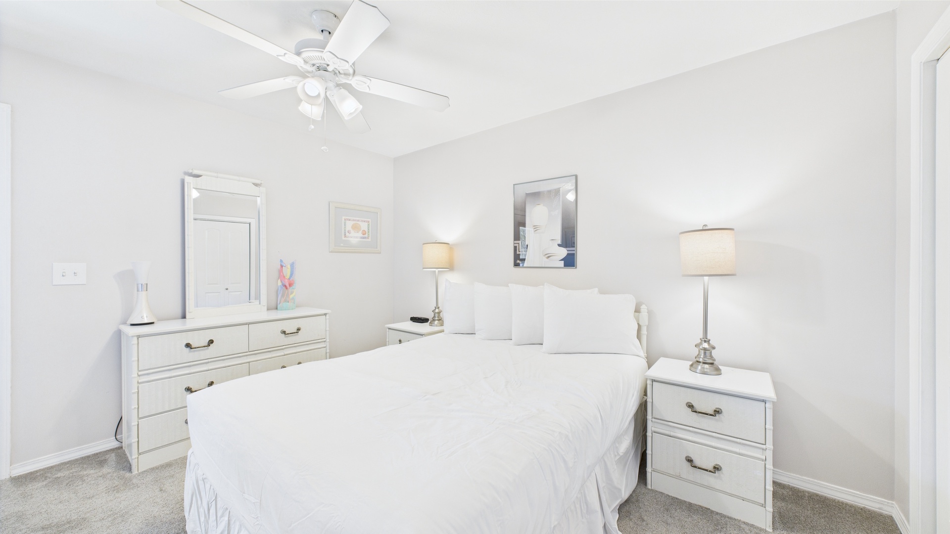 Primary bedroom with queen bed TV and balcony access