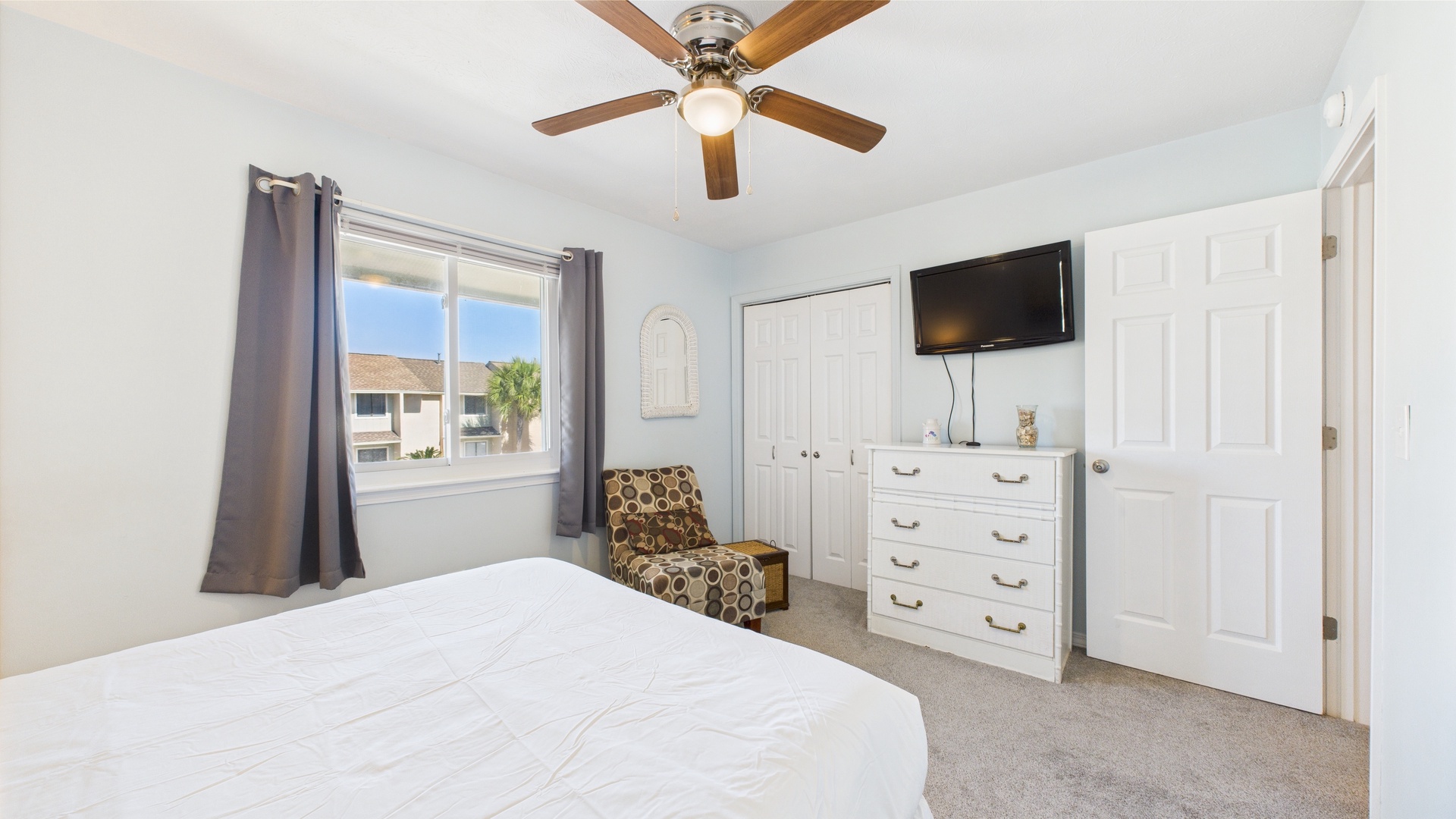 Guest bedroom with queen bed and TV
