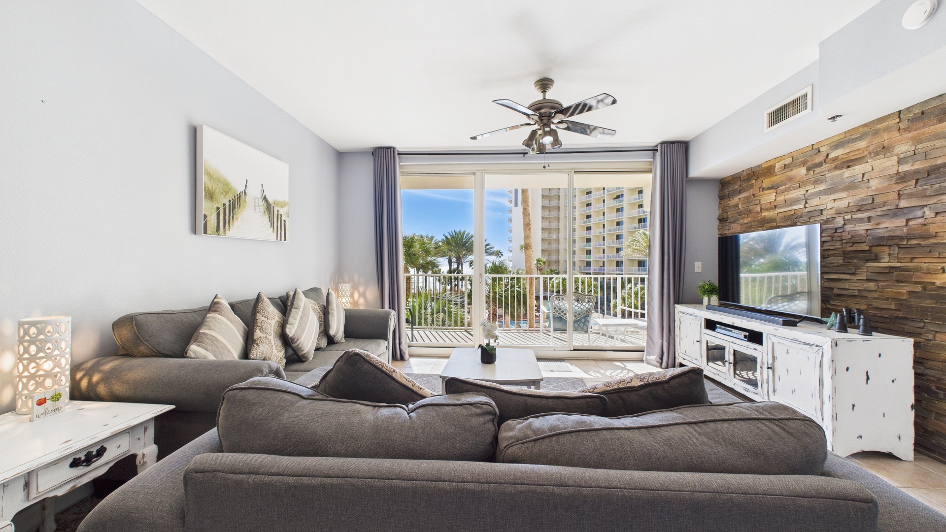 Open concept living area with sleeper sofa TV and balcony access