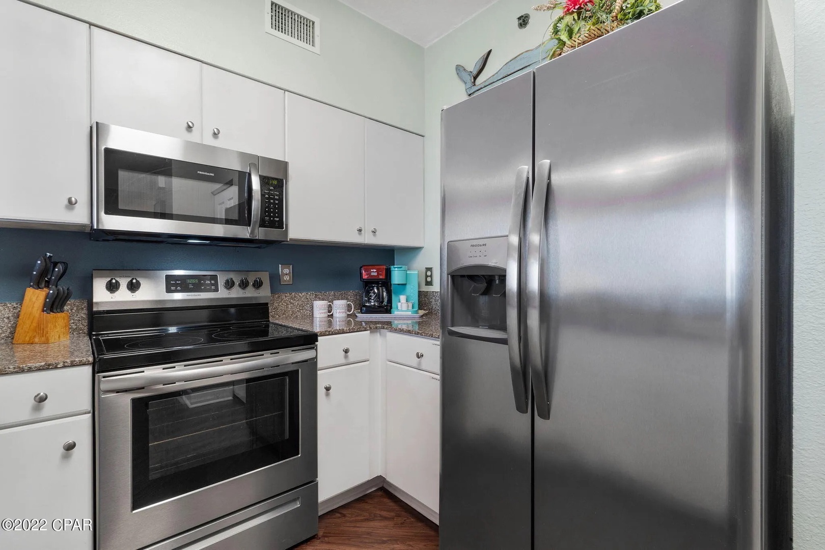 Full kitchen with stainless steel appliances and equipped with basic cooking essentials.