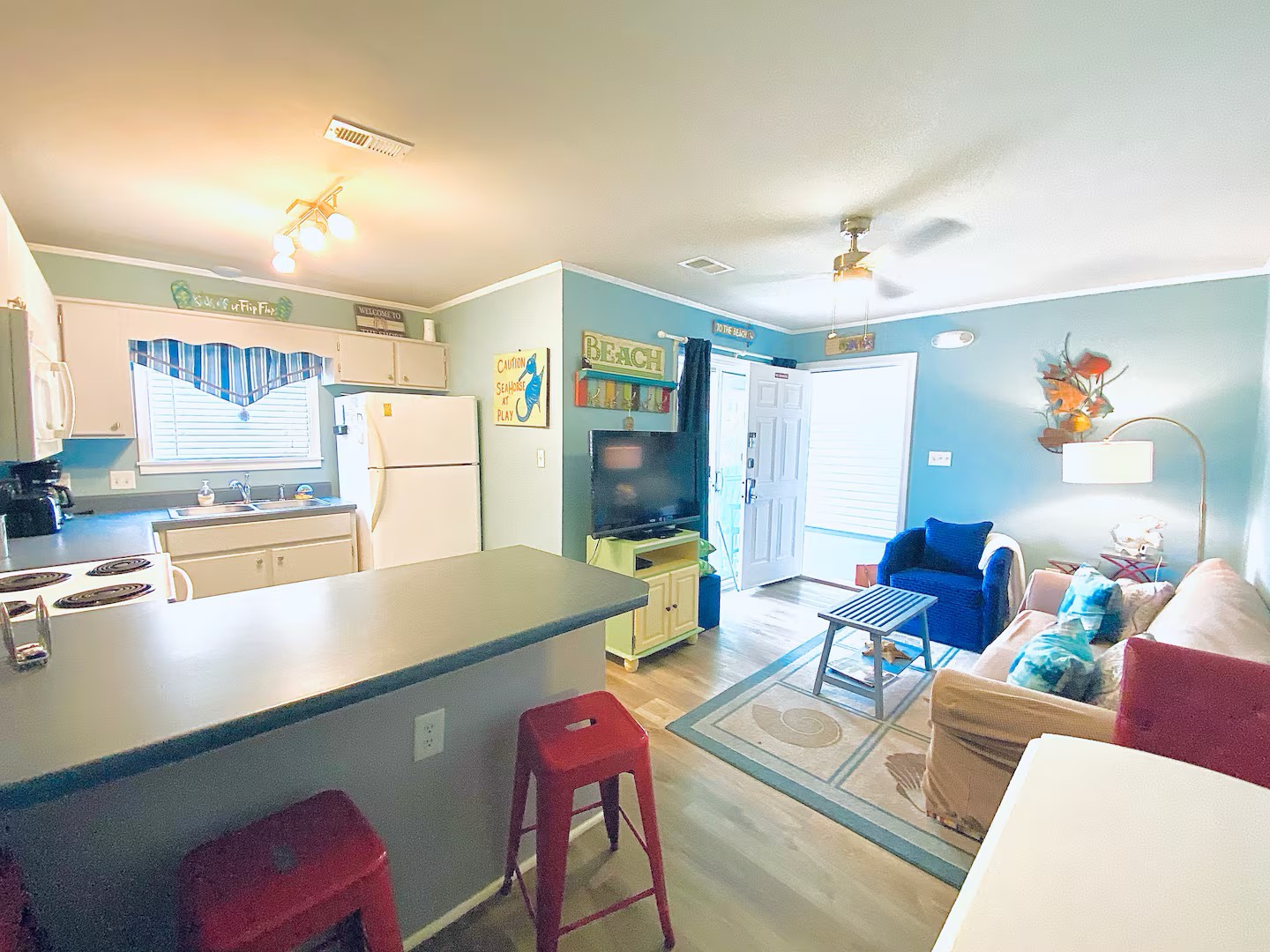 Open concept living area and full kitchen with breakfast bar and dining table