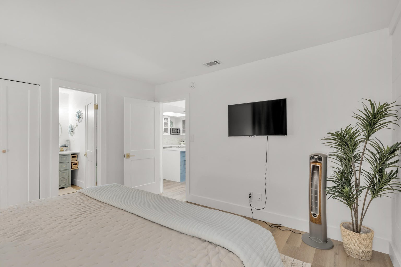 Master bedroom with king bed TV and ensuite bathroom