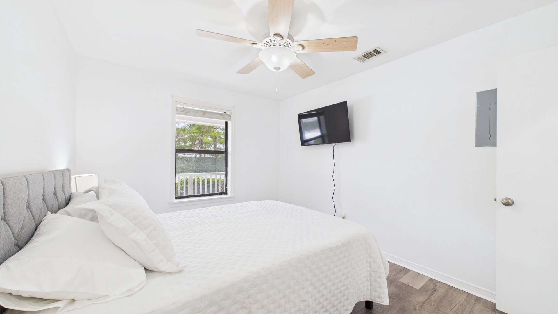Guest bedroom with queen bed TV and balcony access