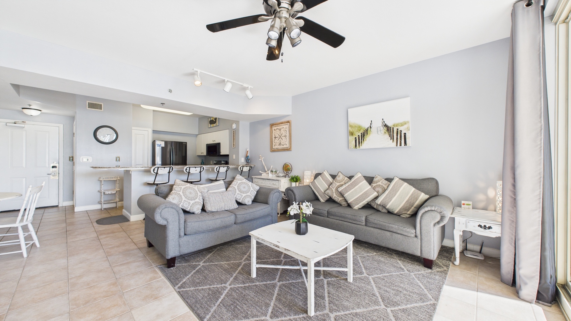 Open concept living area with sleeper sofa TV and balcony access