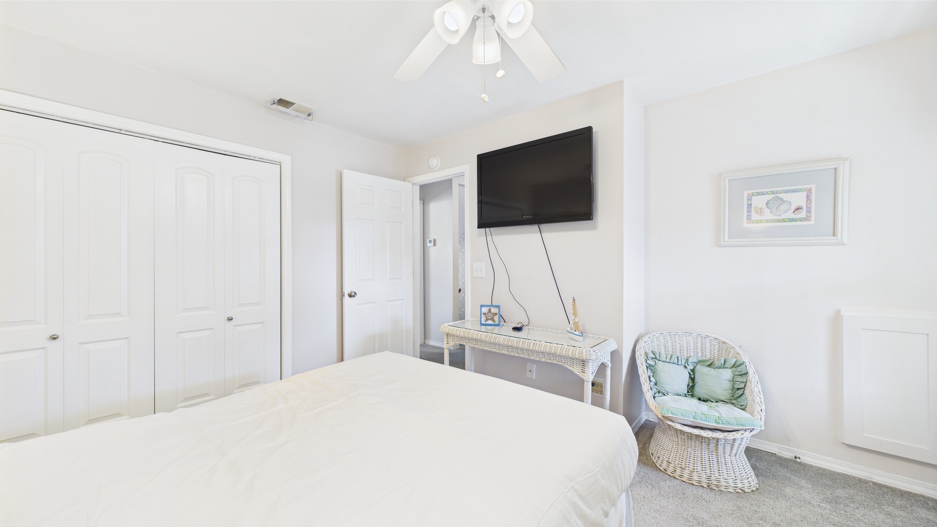 Primary bedroom with queen bed TV and balcony access