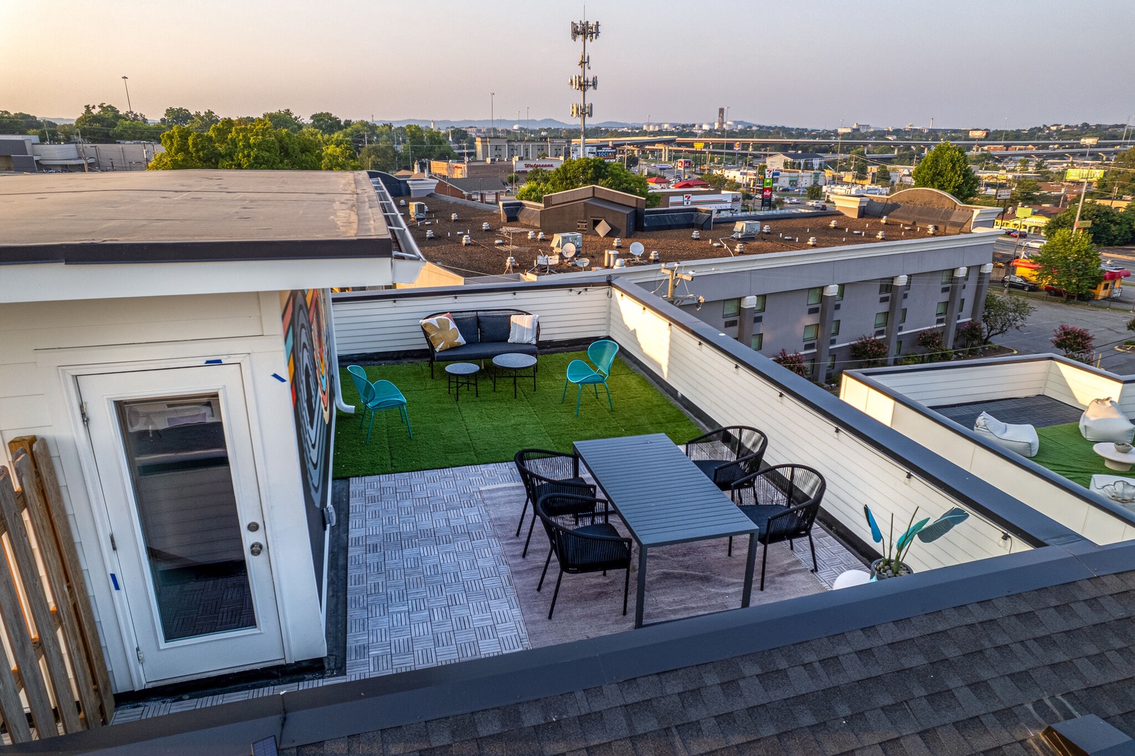 Private rooftop deck outdoor dining table (seats 4) and lounge area. Entire space is lined with bistro lights and includes a photo op mural!