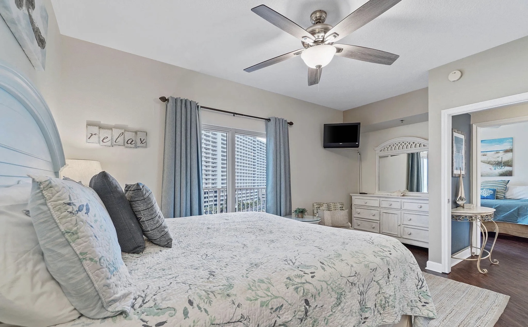 Primary bedroom with king bed, TV, and scenic views. Features an ensuite bathroom.
