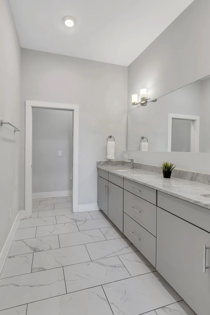 Primary bathroom with dual vanity walk in shower and master closet
