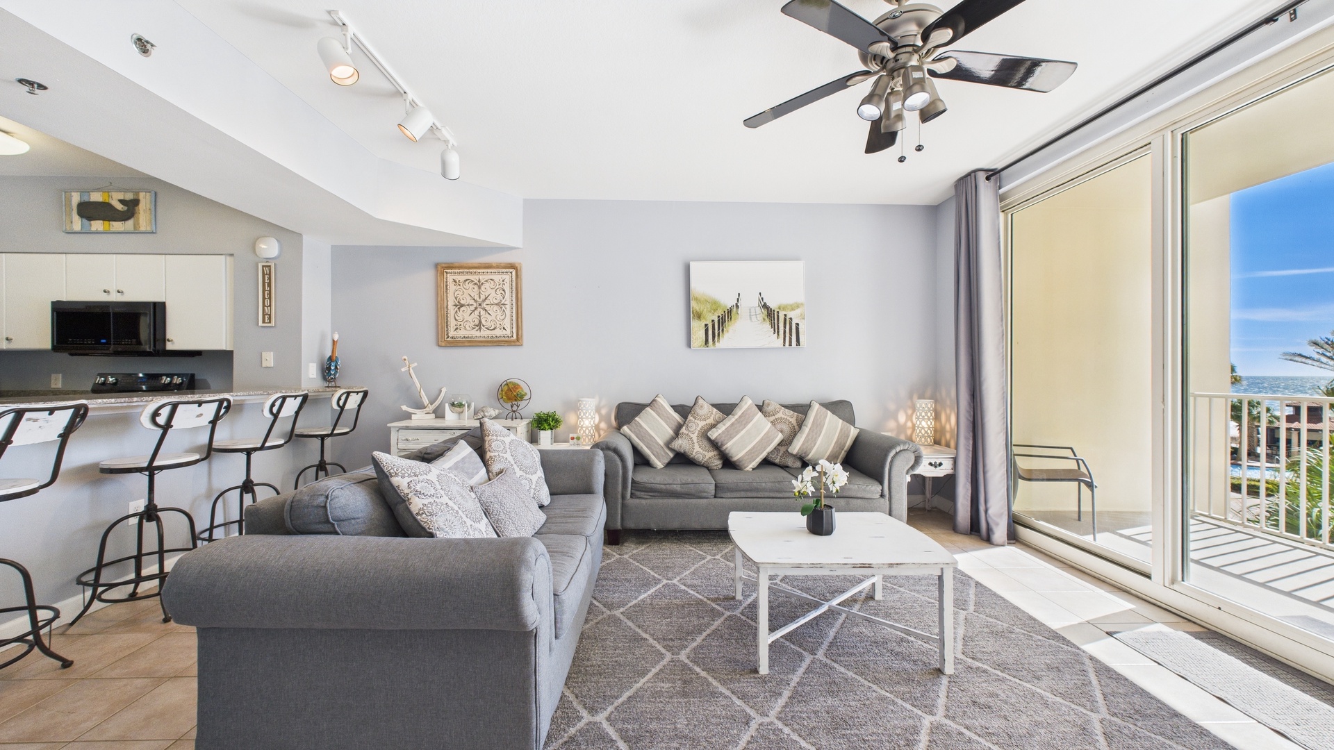 Open concept living area with sleeper sofa TV and balcony access