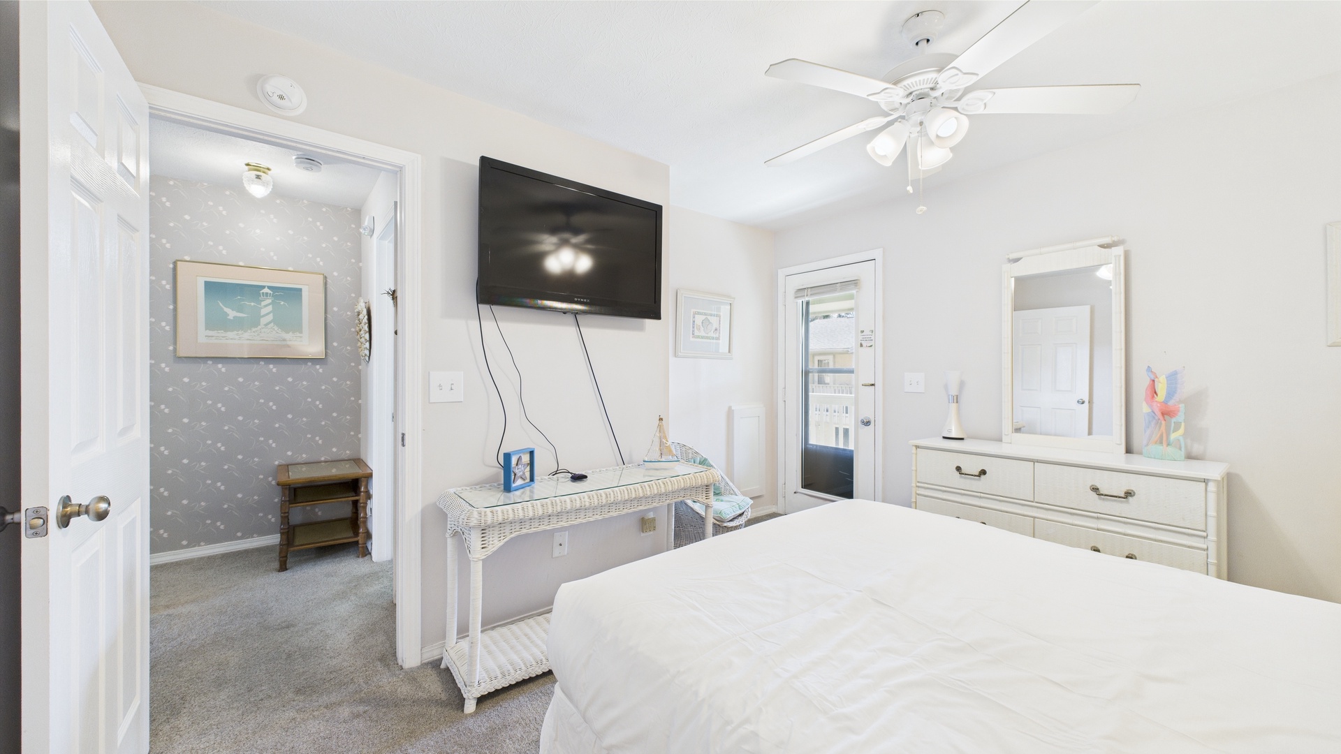 Primary bedroom with queen bed TV and balcony access