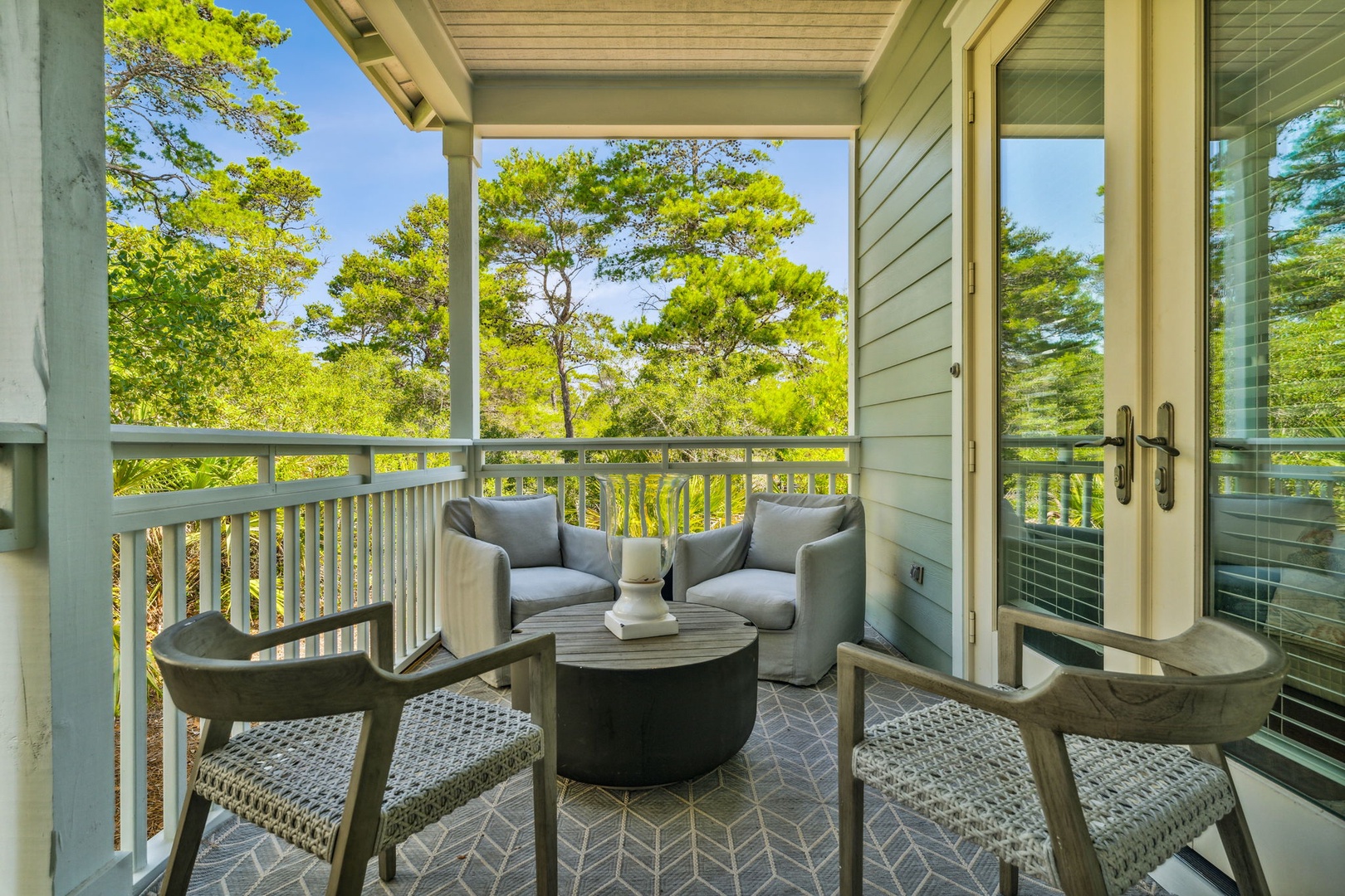 Covered sitting area outside of the master bedroom with seating and a new propane weber grill