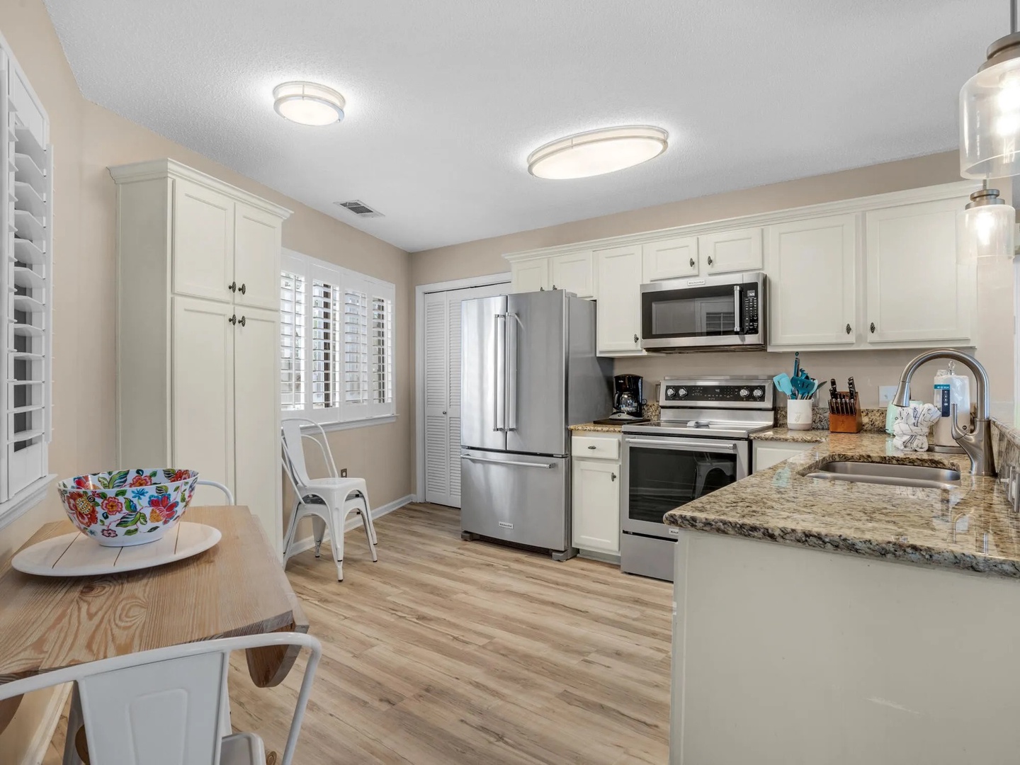Full kitchen with dining area, fully equipped with cooking essentials. Features a breakfast bar with seating for 4.