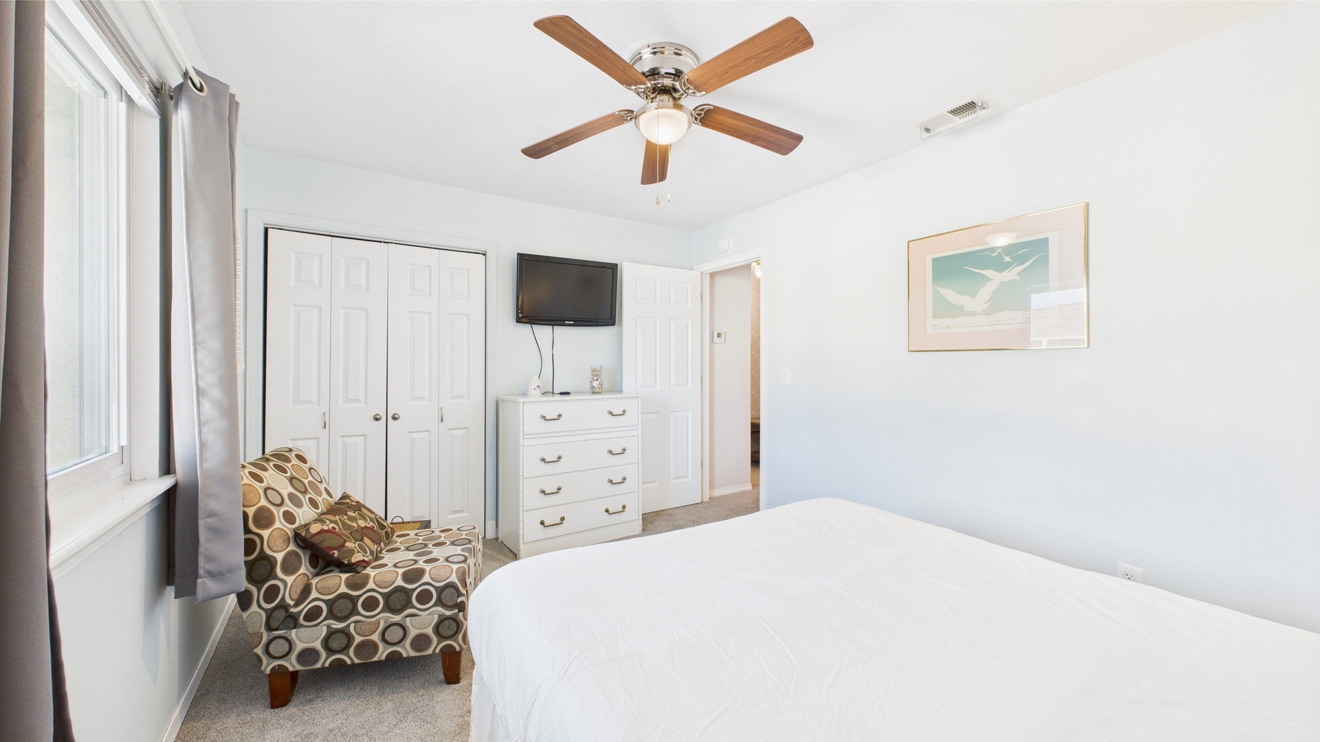 Guest bedroom with queen bed and TV