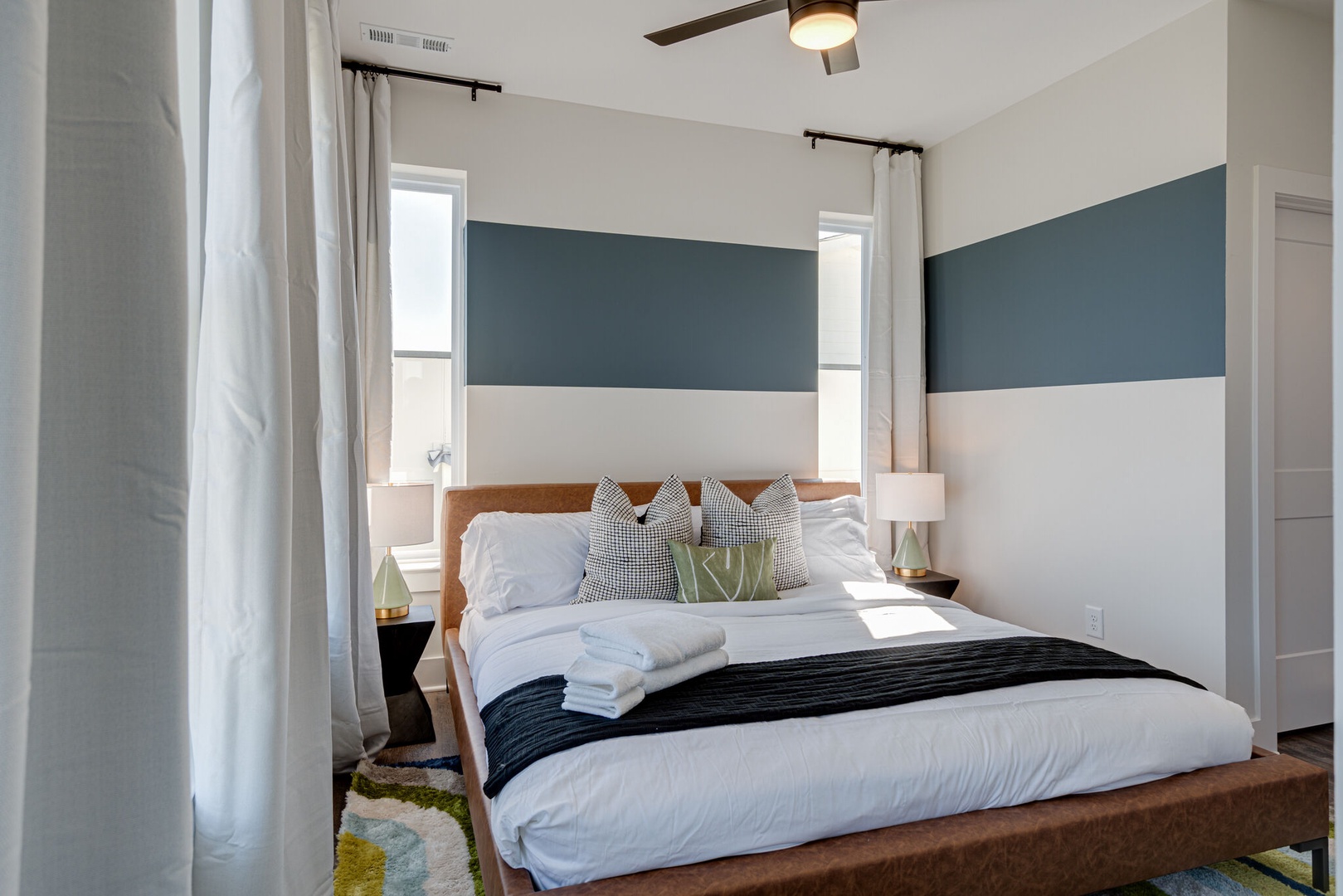 2nd bedroom with King bed, designer furnishings, mural, walk-in closet, and en-suite bathroom.