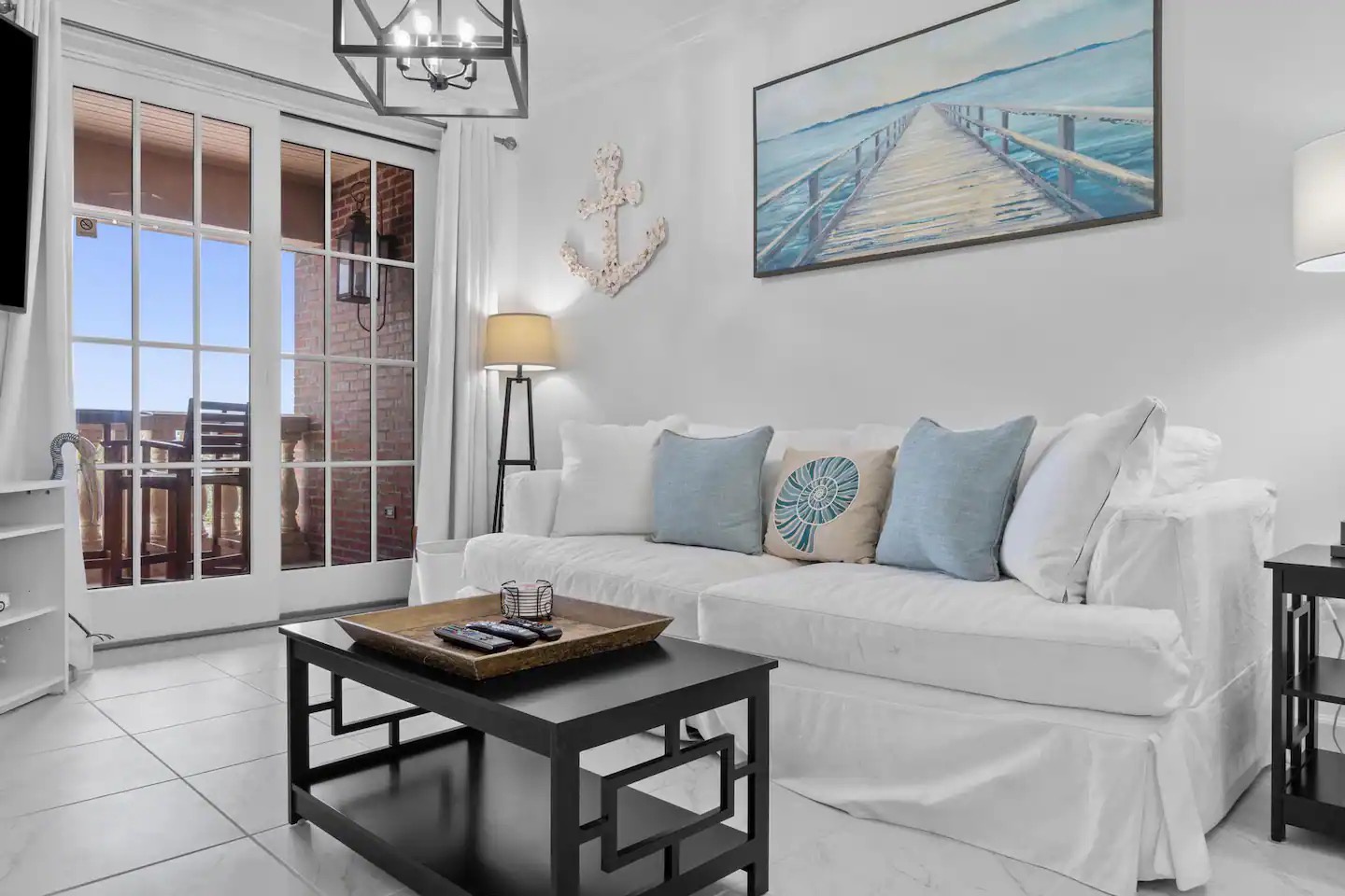 Open concept living area with stylish furnishings balcony access and sofa bed