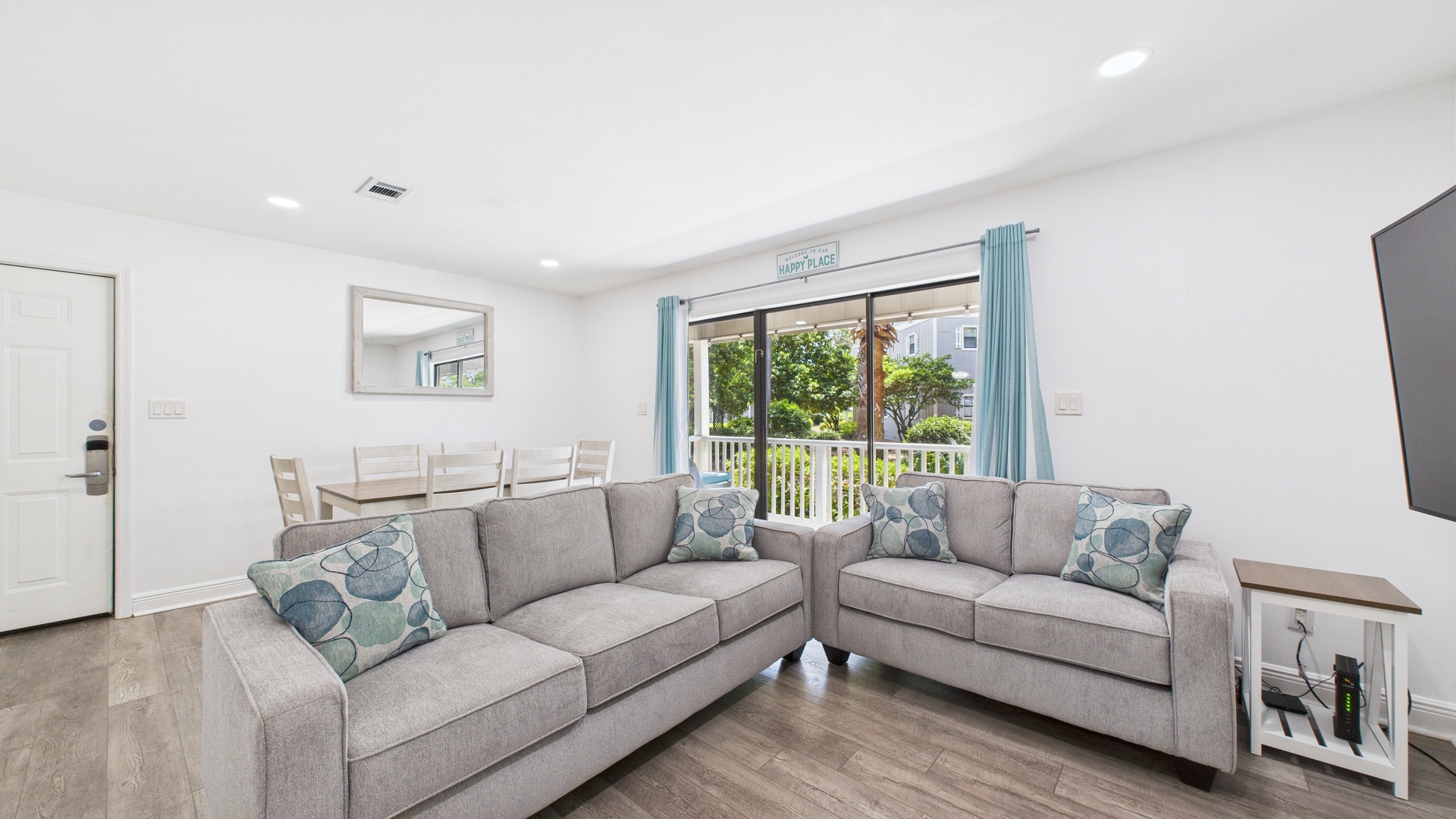 Open concept living area with huge TV and sleeper sofa
