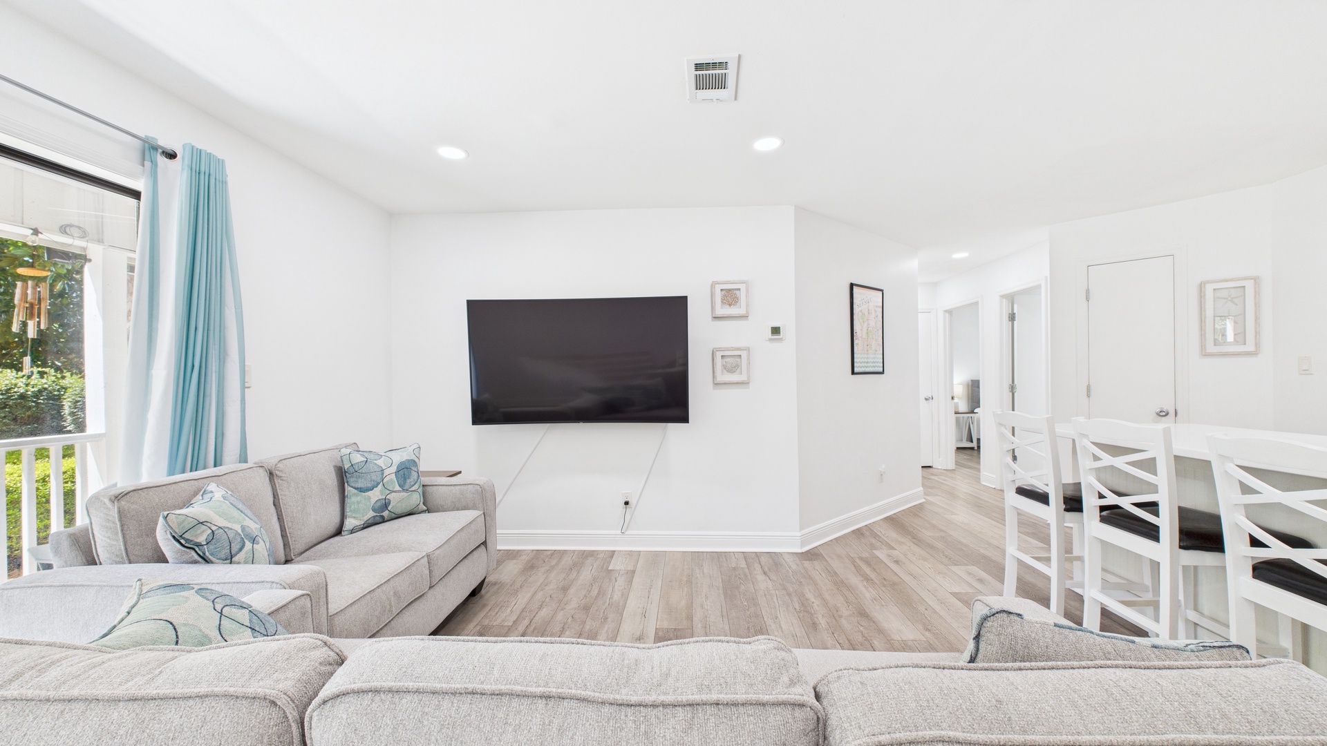 Open concept living area with huge TV and sleeper sofa