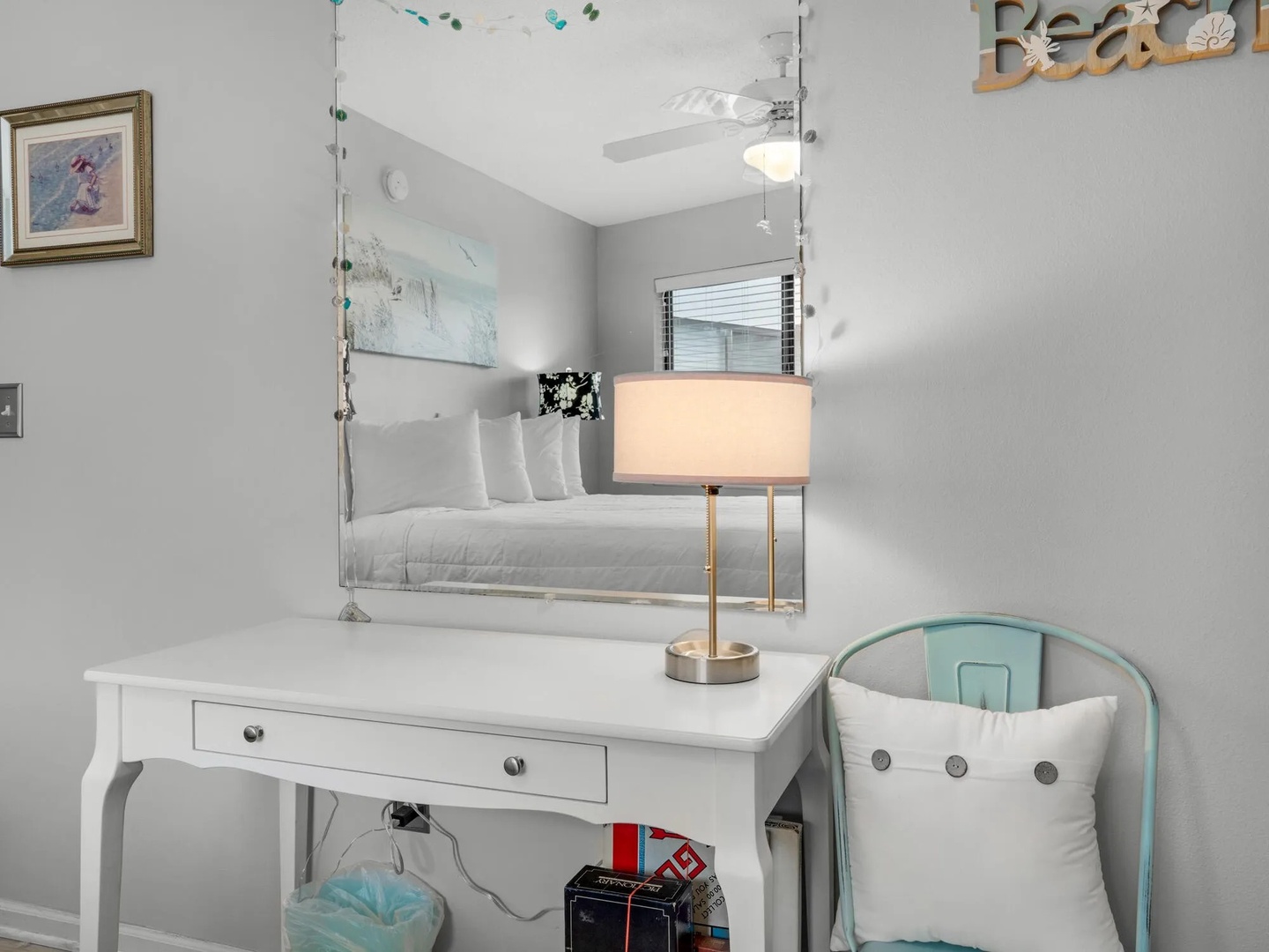Second bedroom with queen bed, vanity table, and TV.