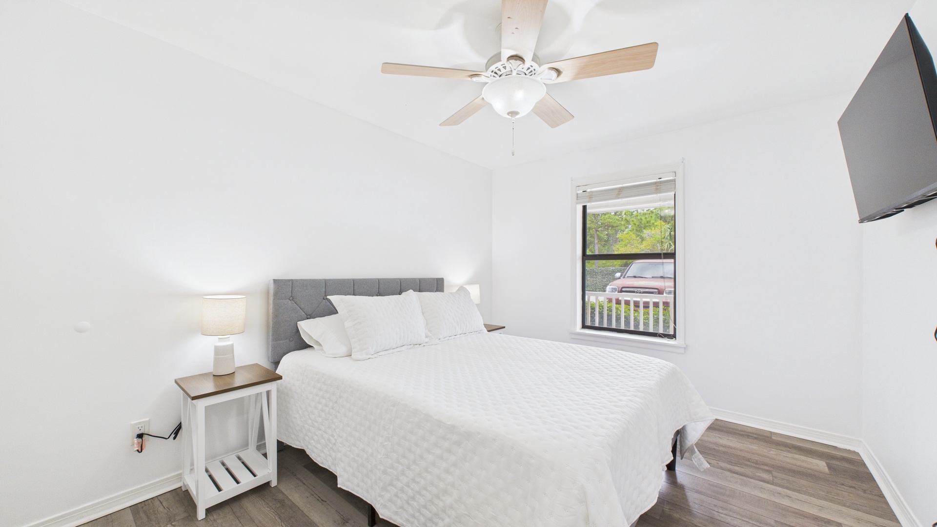Guest bedroom with queen bed TV and balcony access