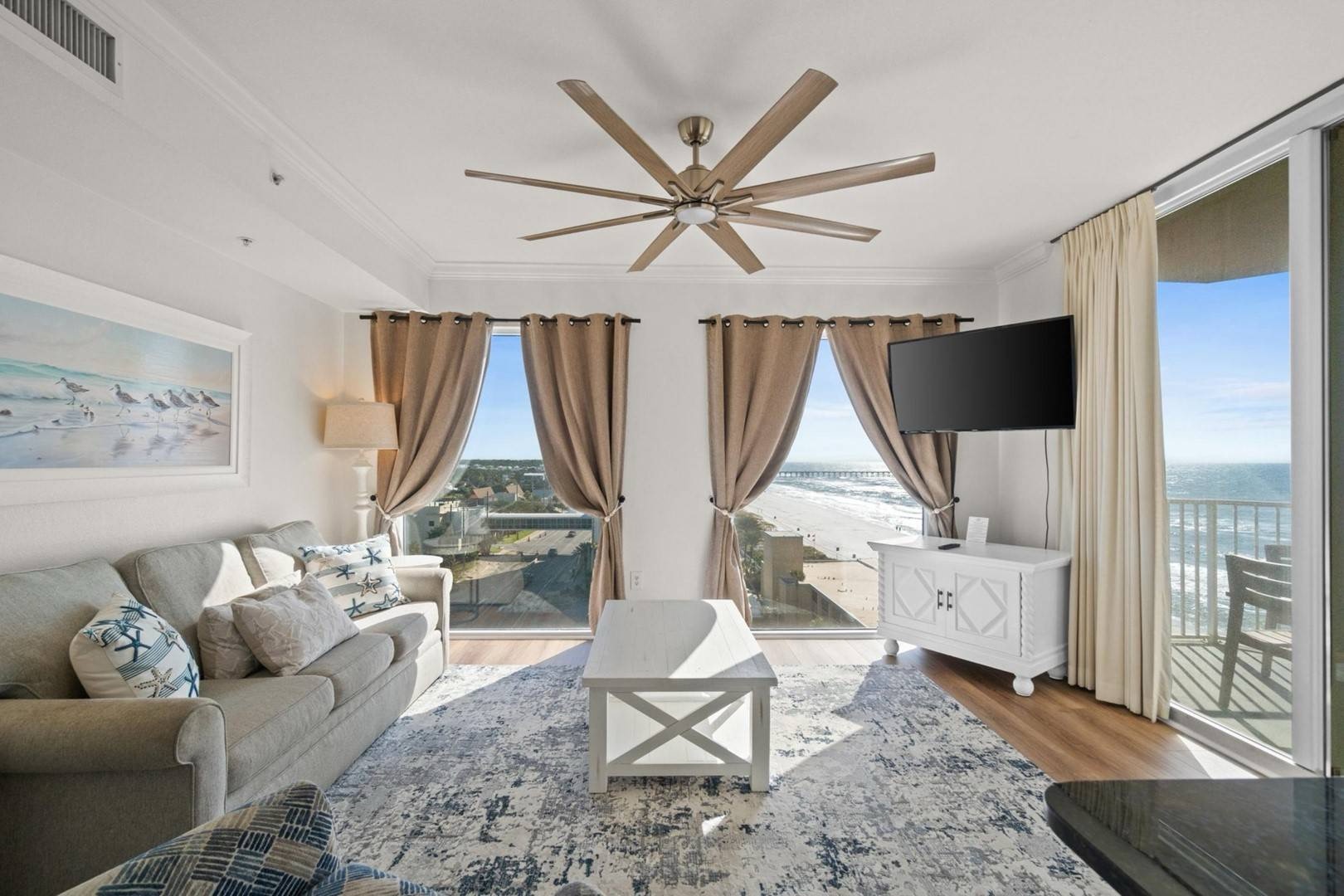 Open concept living area with sleeper sofa TV and balcony access
