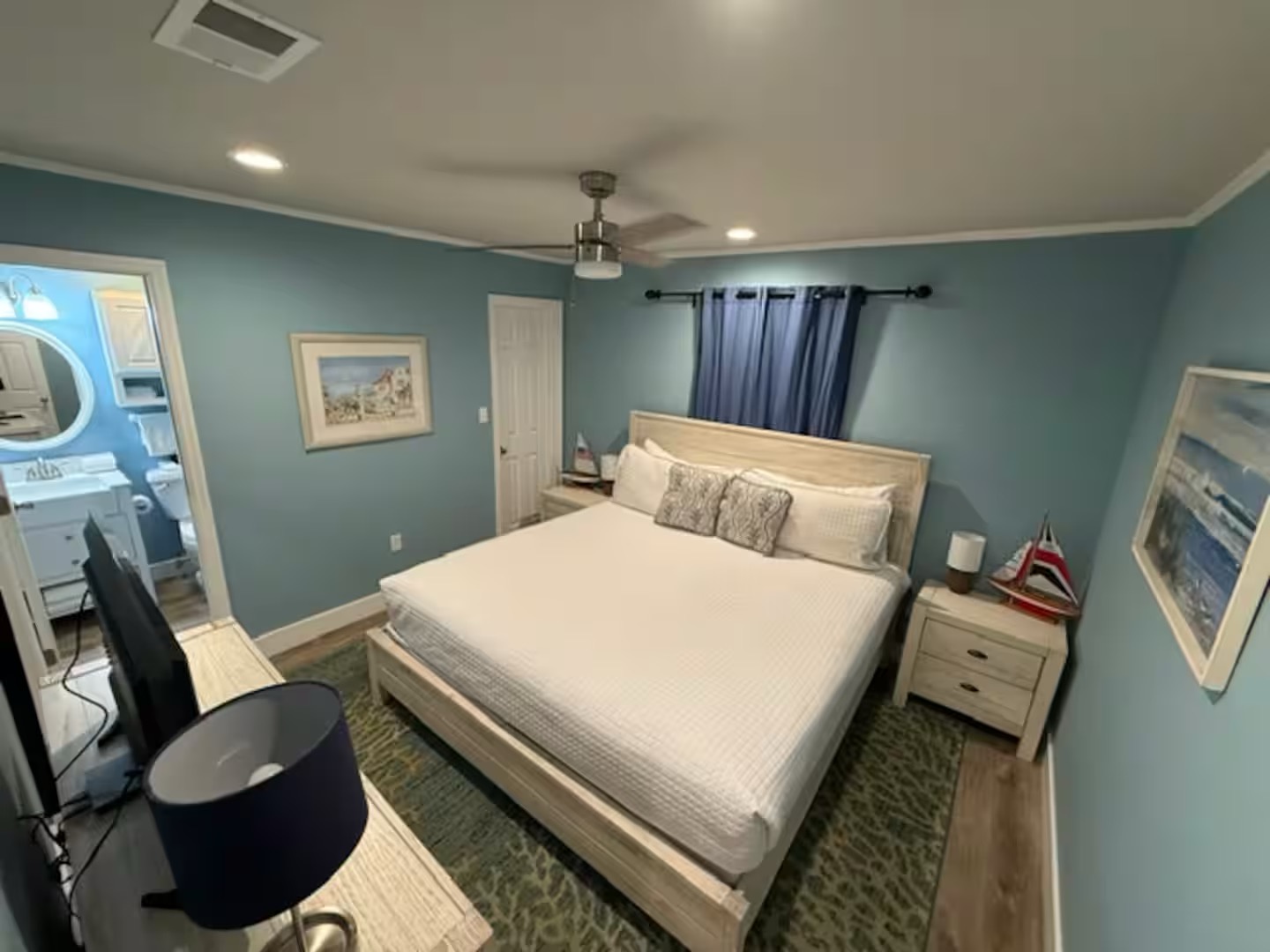 Master bedroom with king bed TV and ensuite bathroom