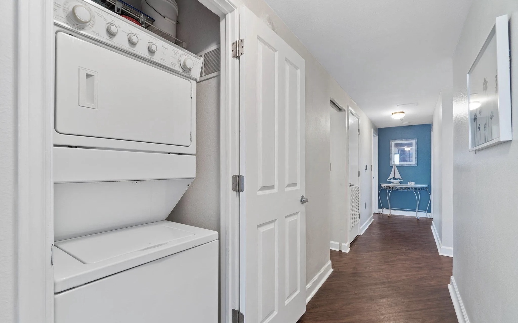 Washer and dryer unit in hallway leading to bedrooms.