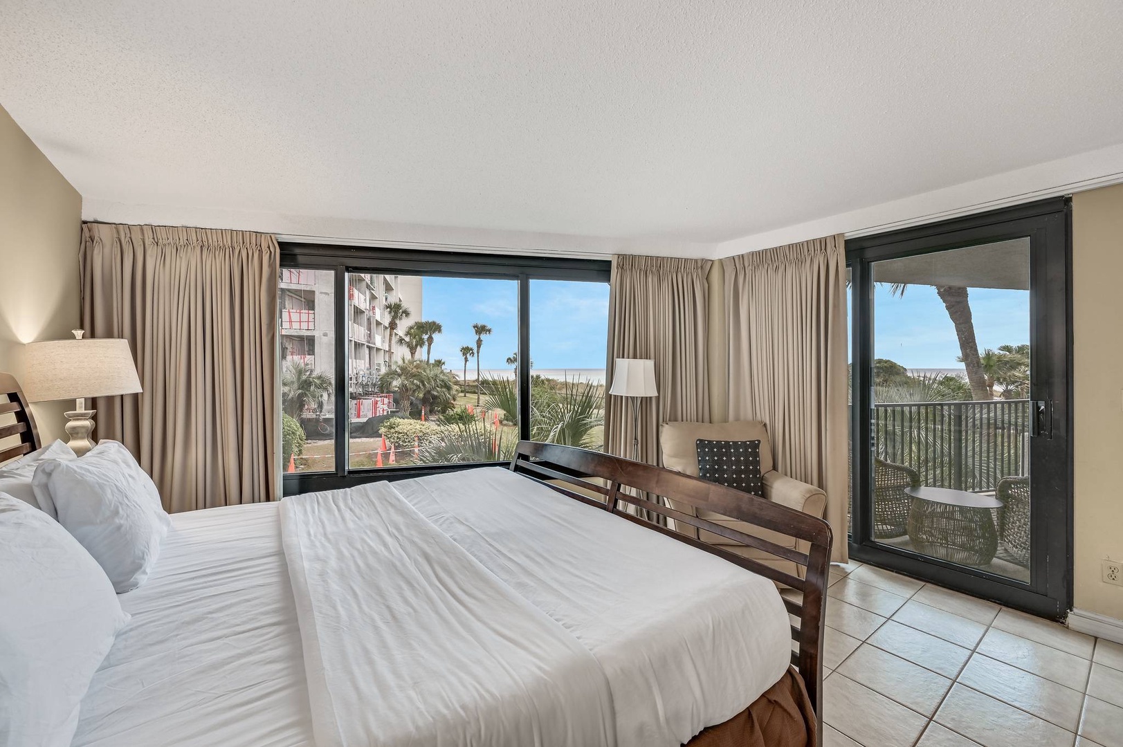 Primary bedroom with king bed TV balcony access and ensuite bathroom