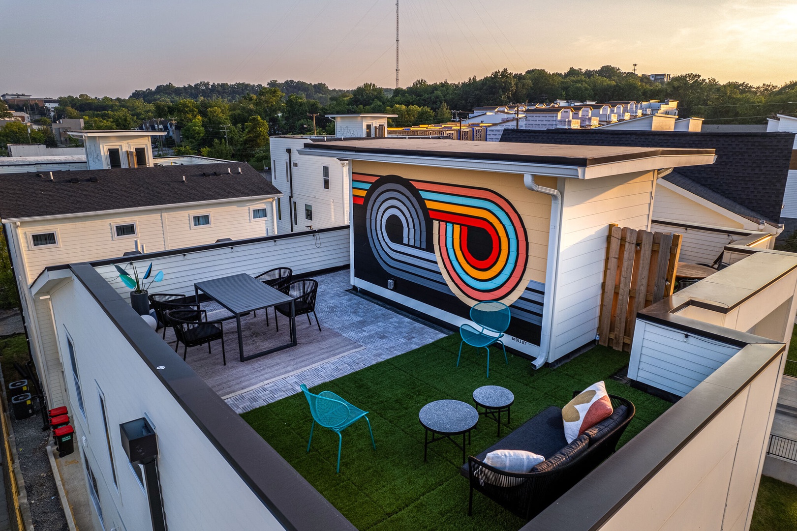 Private rooftop deck outdoor dining table (seats 4) and lounge area. Entire space is lined with bistro lights and includes a photo op mural!