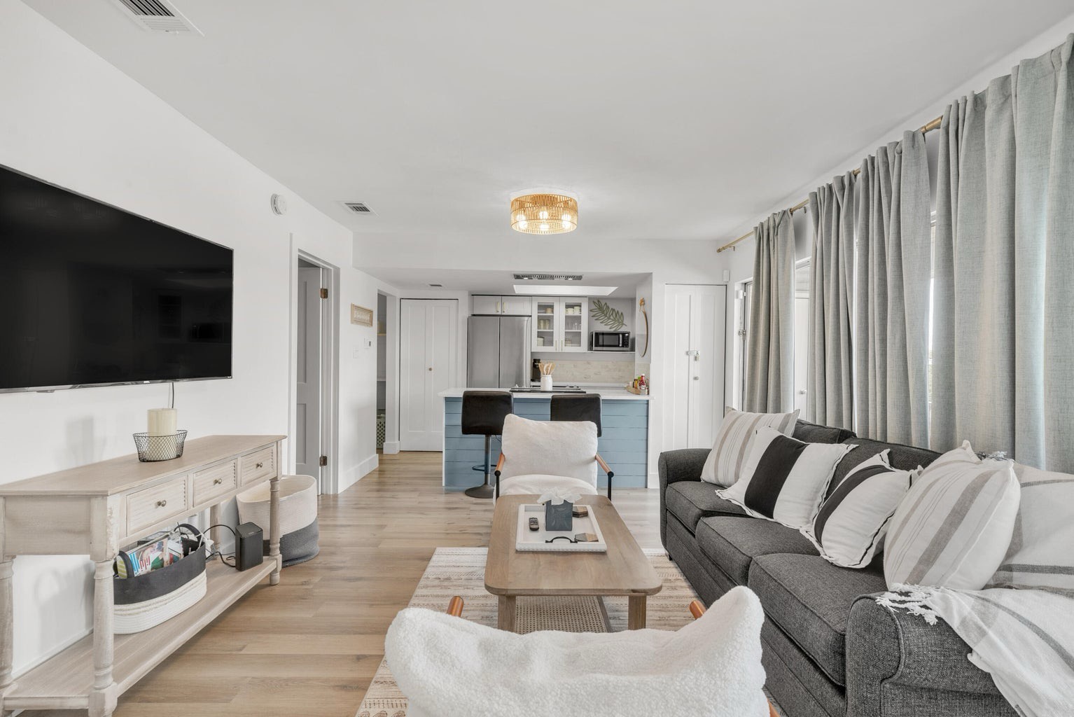 Open concept living area with stylish furnishings TV and pull out couch