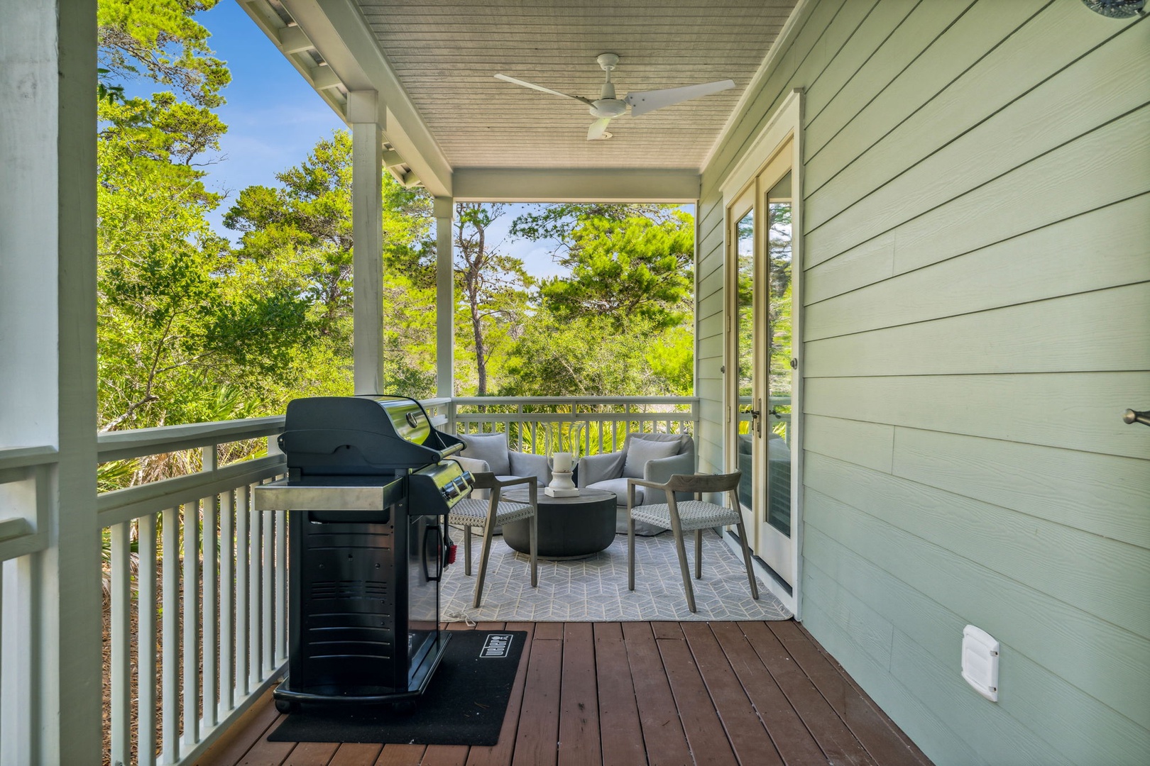 Covered sitting area outside of the master bedroom with seating and a new propane weber grill