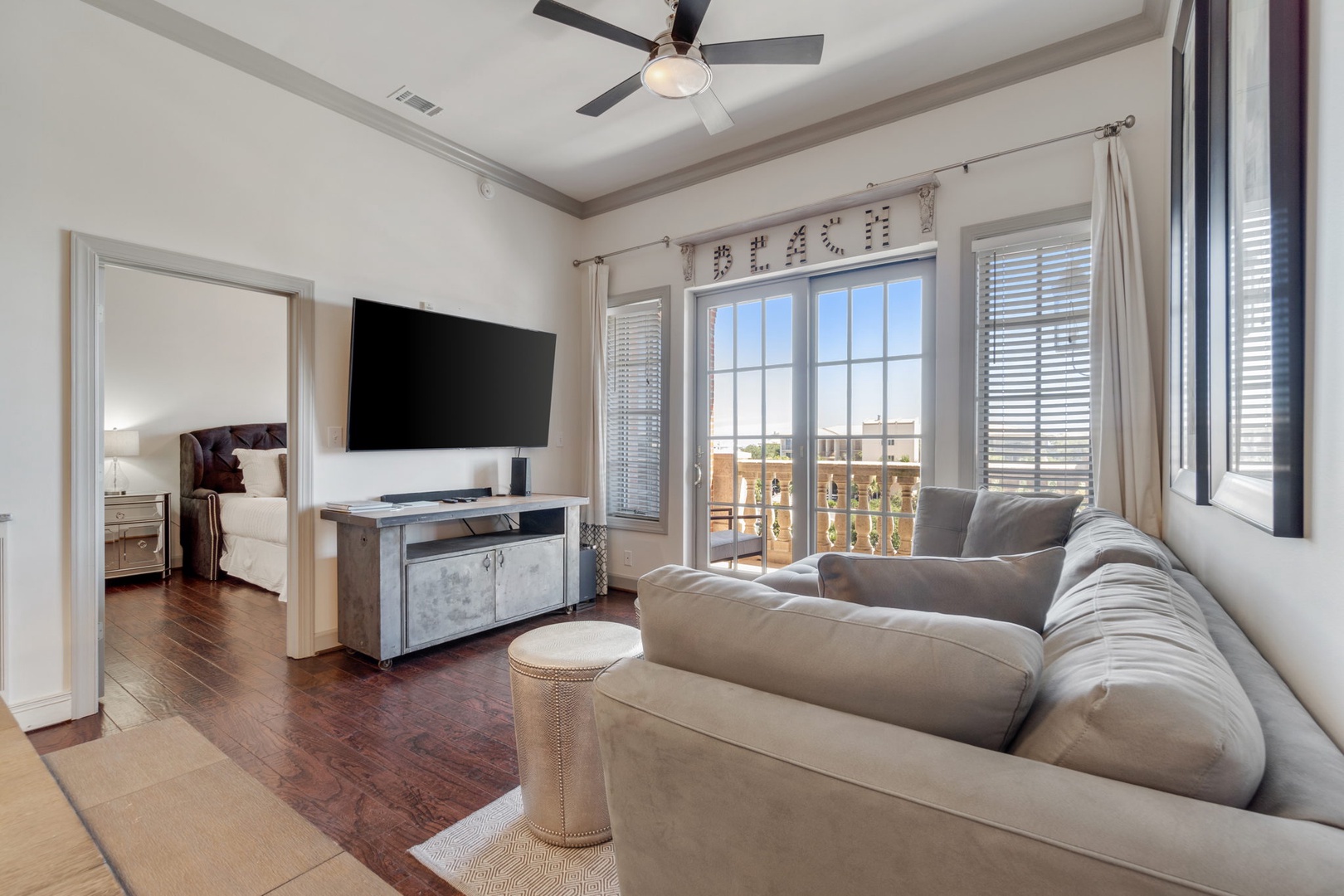 The living room has a large flat screen TV, a sleeper sofa and a private balcony